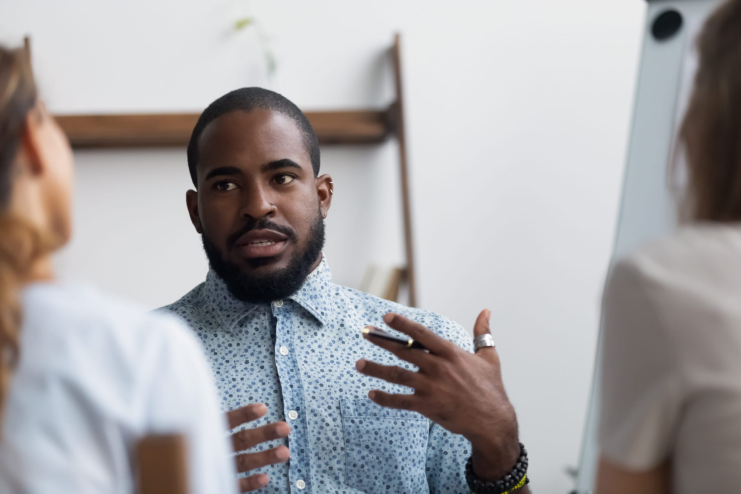 Man speaking openly and expressively in a small group setting, representing the supportive dialogue and self-reflection offered through psychotherapy at the Adelaide Health Clinic